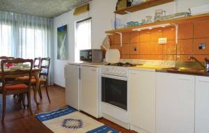 a kitchen with white appliances and a table and a dining room at Apartment House Anton with free parking in Bovec