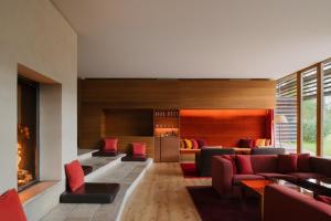 sala de estar con muebles de color rojo y chimenea en Vigilius Mountain Resort, en Lana