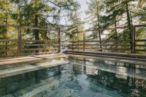 a swimming pool in front of a wooden fence at Vigilius Mountain Resort in Lana