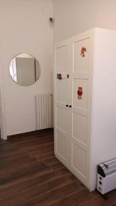 Cette chambre comprend une armoire blanche et un miroir. dans l'établissement PARTENOPE 120 mq, à Naples