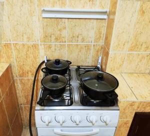 a stove with two pots on top of it at Cálido Garzonier en Sopocachi in La Paz