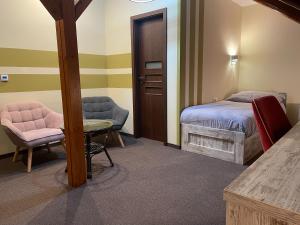リフノフ・ナト・クニェジュノウにあるHotel Hermanのベッドルーム1室(ベッド1台、テーブル、椅子付)