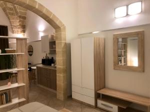 cocina con arco y nevera blanca en Happy Loft Salento, en Cellino San Marco