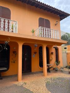 a yellow house with a balcony and a patio at Estações in Campinas