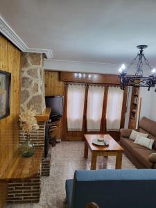 ein Wohnzimmer mit einem Sofa und einem Tisch in der Unterkunft Casa Hermi in Arenas de San Pedro