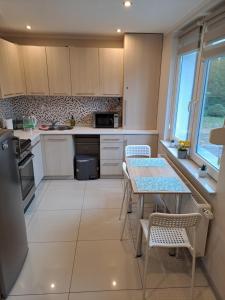 a kitchen with white cabinets and a table and chairs at Cztery Kąty Apartament Wągrowiec in Wągrowiec
