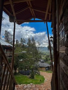 una vista desde el porche de una casa en Palu Ecoaldea, Cabañas glamping en medio del bosque en Tenjo