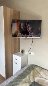 TV de pantalla plana en la pared de un dormitorio en SalzinnesChezSoi, en Namur