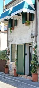 een gebouw met een groene deur en een paraplu bij Piccola Casa Shabby 500m castello di Este in Este