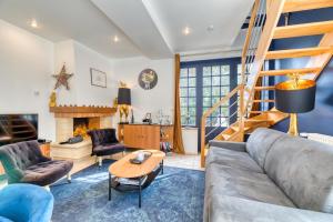 ein Wohnzimmer mit einem Sofa und einem Tisch in der Unterkunft Le Clos des Roches in La Bouille