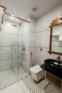 a bathroom with a toilet and a glass shower at The Experience Resort-Lake Facing in Udaipur