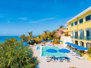 an aerial view of a hotel with a pool and chairs and umbrellas at Hotel Capizzo in Ischia