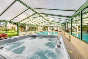 a large hot tub in a building with windows at Le Clos des Roches in La Bouille