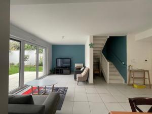 sala de estar con sofá y mesa en Duplex NEUF 90 m2 - 3 chambres, avec jardin à Sartrouville, en Sartrouville