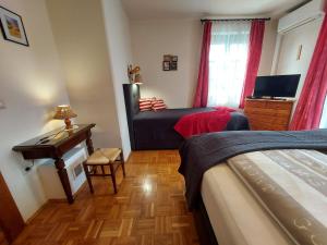 una camera con letto, scrivania e finestra di Titi Family Apartman a Bük