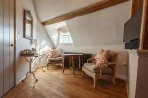 a attic room with two chairs and a table at The Dial House in Reepham
