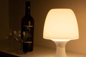 - une bouteille de vin à côté d'une lampe et des verres à vin dans l'établissement APPARTAMENTO LA ROCCA, à Manerba del Garda