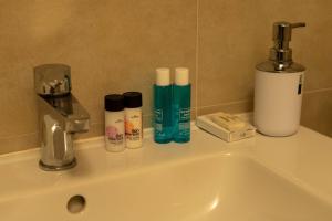 W łazience znajduje się umywalka z zestawem kosmetyków. w obiekcie APPARTAMENTO LA ROCCA w Manerba del Garda
