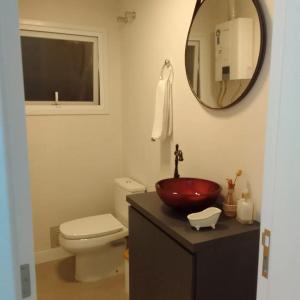 uma casa de banho com um lavatório vermelho e um WC. em LOFT 235 CANELA em Canela
