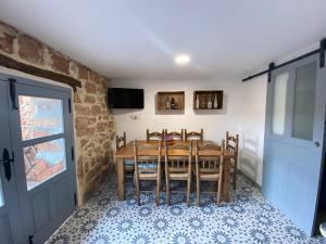a dining room with a wooden table and chairs at La Casa Rural de Pálmaces in Pálmaces de Jadraque