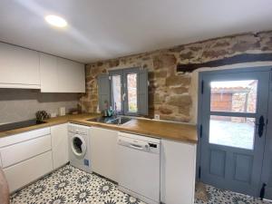 a kitchen with a sink and a washing machine at La Casa Rural de Pálmaces in Pálmaces de Jadraque