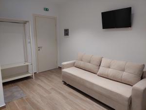 a living room with a couch and a flat screen tv at Emi's Villa in Ksamil
