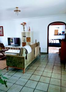 a living room with a couch and a tv at Casa Strelitzia in Nazaret