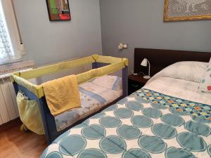 a bedroom with a bed and a crib with a blanket at CASA LOS BLOQUES in Zamora