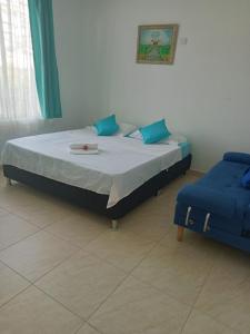 a bedroom with a bed and a blue chair at Casa Campestre con Piscina Jacuzzi y Golfito in Villavicencio