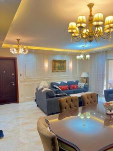 een woonkamer met een bank en een tafel bij Ultra Luxury 3BR with Pools ,Sports ,Dining in Gated compound, Close to all sites in Caïro