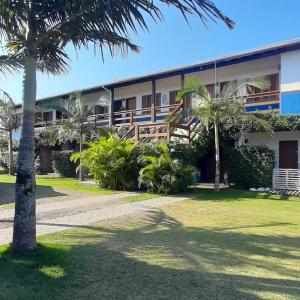 un edificio con palmeras delante en Pousada Lagoa do Rosa, en Praia do Rosa