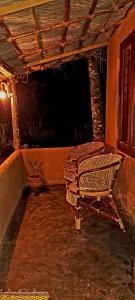 eine Veranda mit 2 Stühlen, einem Tisch und einer Pflanze in der Unterkunft Gowings Sahaara in Idukki