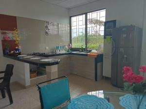 a kitchen with a sink and a refrigerator at Casa Campestre con Piscina Jacuzzi y Golfito in Villavicencio