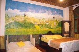 a bedroom with two beds and a painting on the wall at MF Holiday Bungalow in Bandarawela
