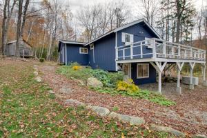 a blue house with a deck in the woods at Weston Vacation Rental - Close to Ski Resorts! in Weston