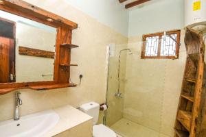 a bathroom with a toilet and a shower and a sink at Majani Breeze in Nungwi
