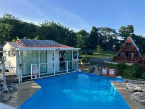 a house with a swimming pool and a house with a building at Cabaña 787 in Lares