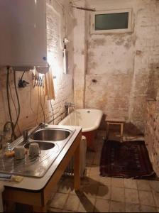 een vuile badkamer met een wastafel en een bad bij Old Industrial Central Atelier in Wenen