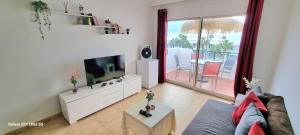 a living room with a couch and a tv and a balcony at Bella Vista 414-Ocean Lanzamar- Puerto Del Carmen in Tías