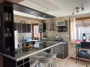 a kitchen with a counter and some stools in it at La casa de la colina in San Carlos de Bariloche