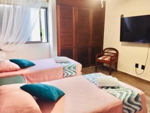 Cette chambre comprend 3 lits et une télévision à écran plat. dans l'établissement Flamingo Plus Ocean View, à Cancún