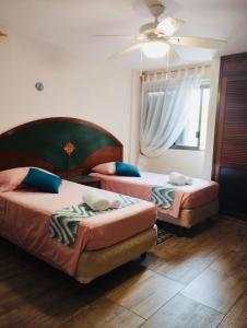 - une chambre avec 2 lits et un ventilateur de plafond dans l'établissement Flamingo Plus Ocean View, à Cancún
