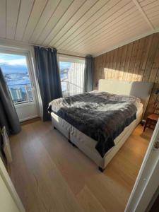 um quarto com uma cama e uma grande janela em Kikut Panorama, Geilo - sleeps 9pax, ski in/out - Modern 2 floor apart em Geilo