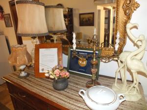 una mesa con lámpara, un espejo, una foto y flores en La Chicca, en Carrara