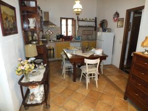 cocina con mesa, sillas y nevera en La Chicca, en Carrara