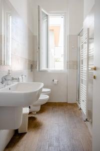 a bathroom with a sink and a tub and a window at Casa Aydée in Bergamo