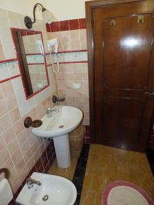 baño con lavabo, espejo y puerta en La Chicca, en Carrara