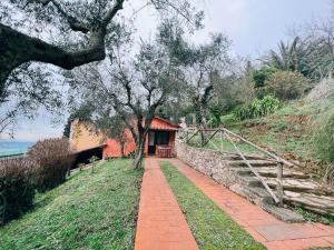 einen Backsteinweg, der zu einem Haus mit einem Baum führt in der Unterkunft Borgo degli Aranci in San Giuliano Terme