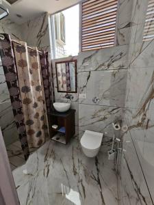 a marble bathroom with a toilet and a sink at Ankhi's Villa with Parking in Amritsar