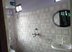 uma casa de banho com um lavatório e um espelho na parede em Sunyog Homestay em Pedong